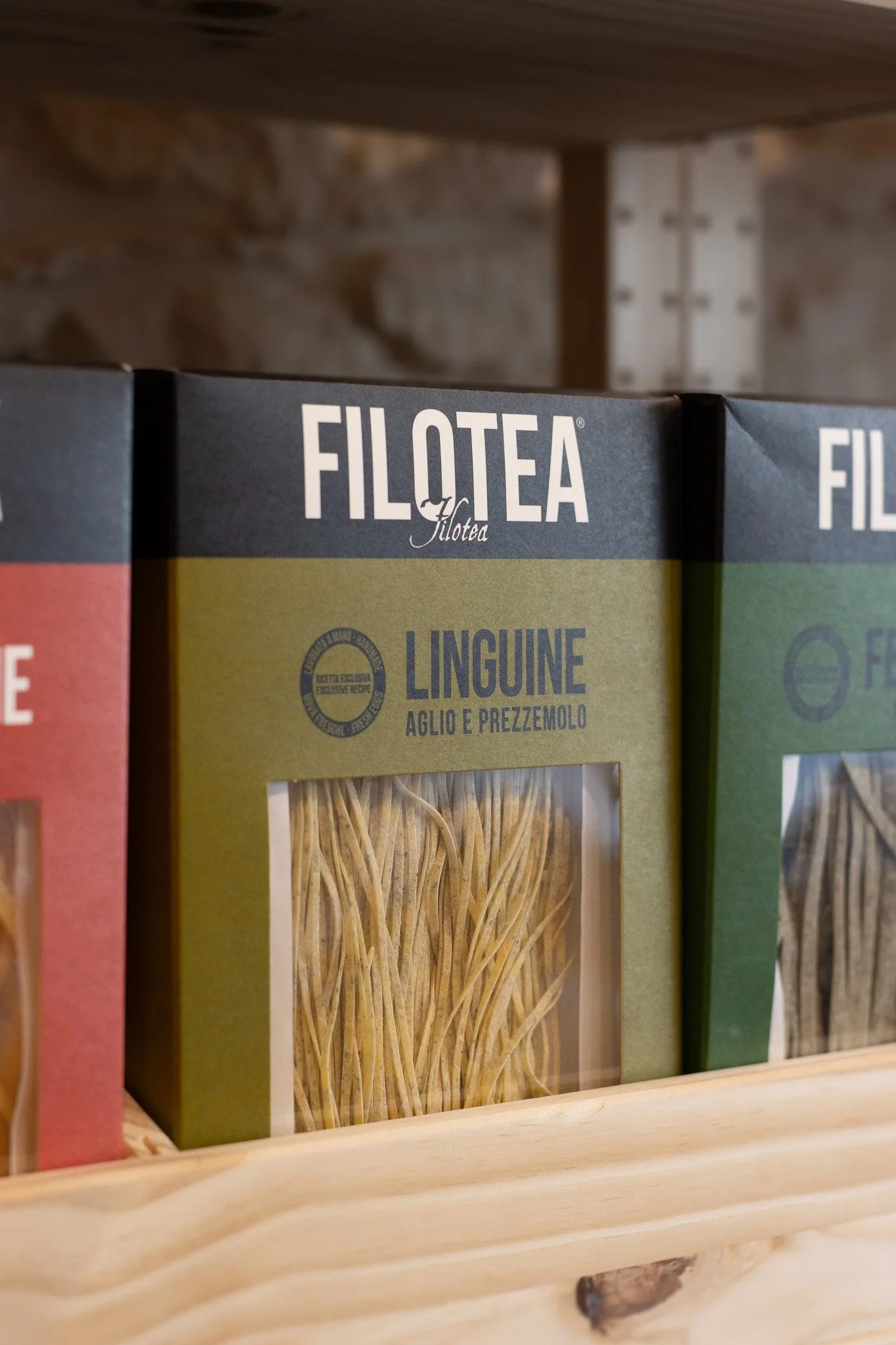 Boxes of pasta on a wooden shelf, labeled 'FILO TEA' with flavor 'Linguine' containing garlic and parsley. The Cotswold Farm.