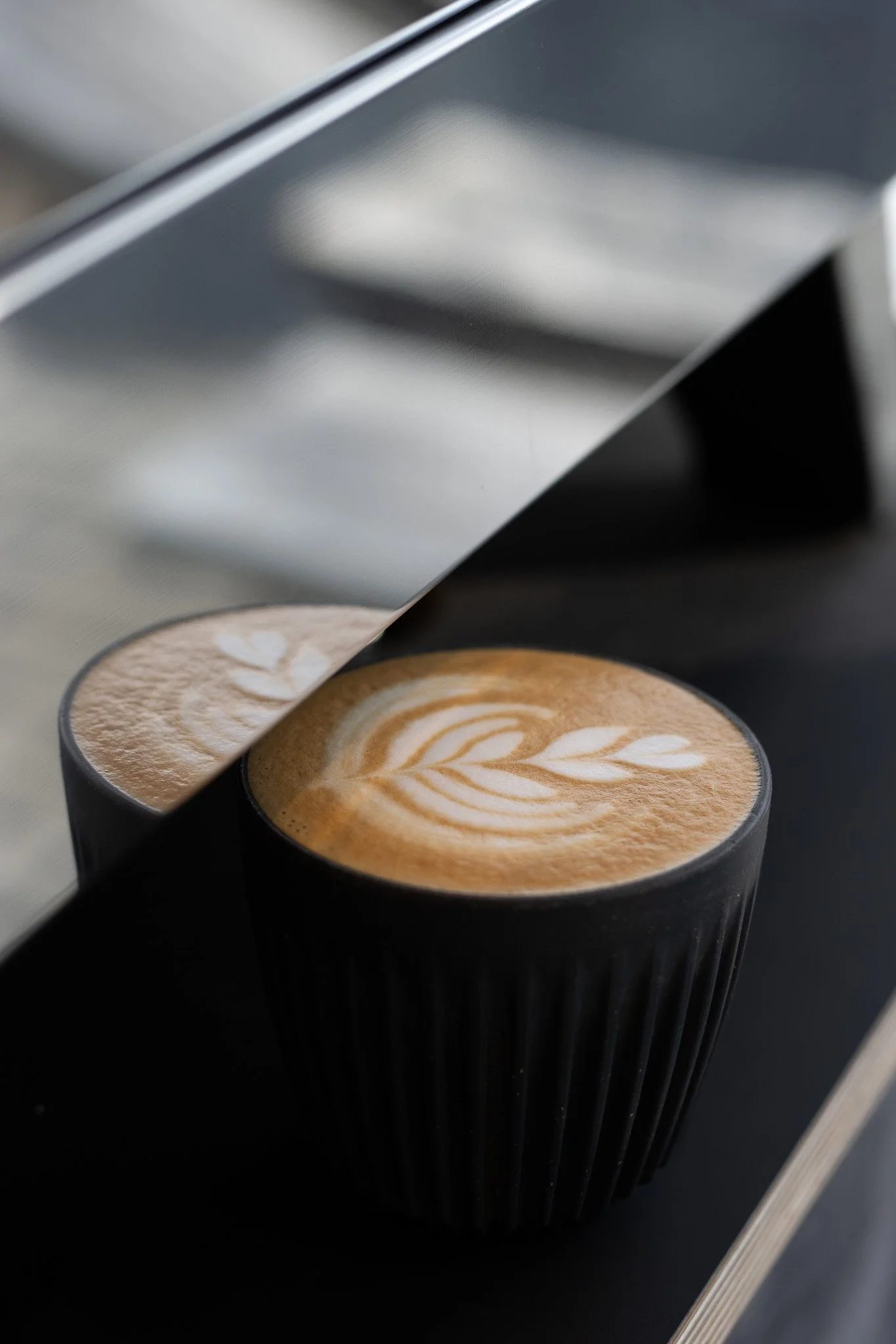 Close-up of a black coffee cup with latte art in a coffee machine. The Scandinavian Coffee Pod.