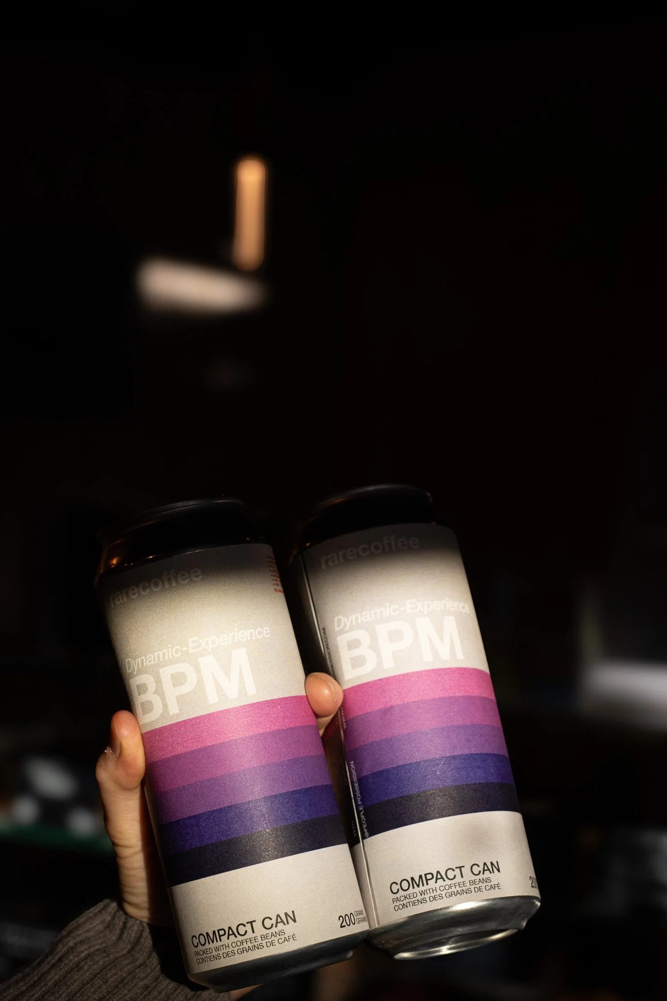 Two cans of coffee sitting on a hand with a dark background. The Scandinavian Coffee Pod.