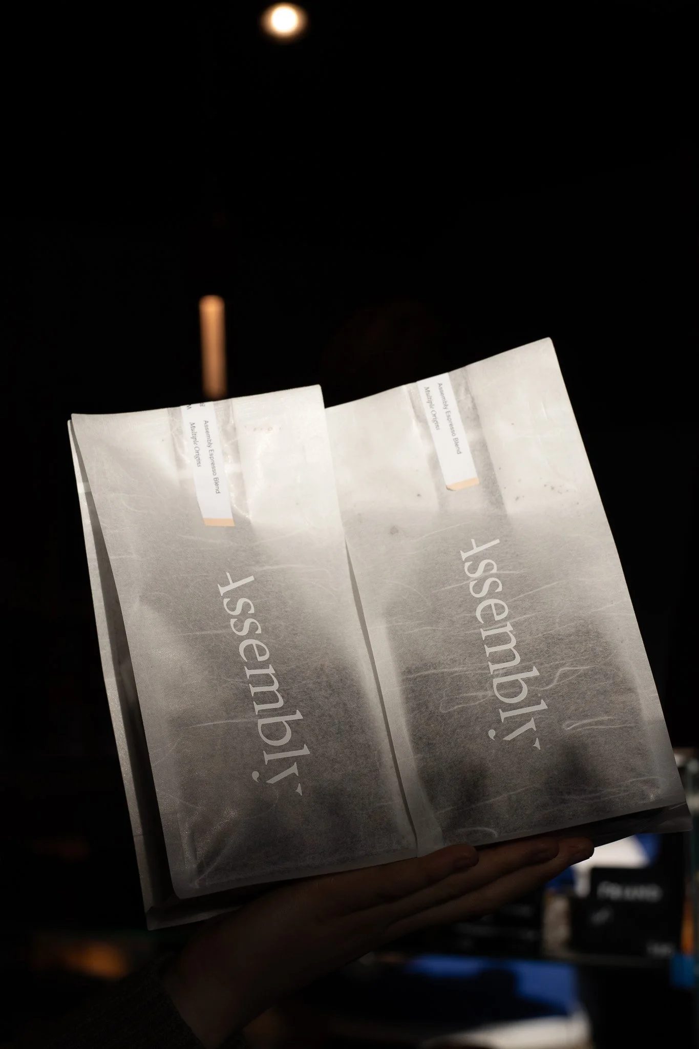 A person holding a program or brochure with the partially visible text 'Disclaimer' in a dark setting with a bright moon in the background. The Scandinavian Coffee Pod.