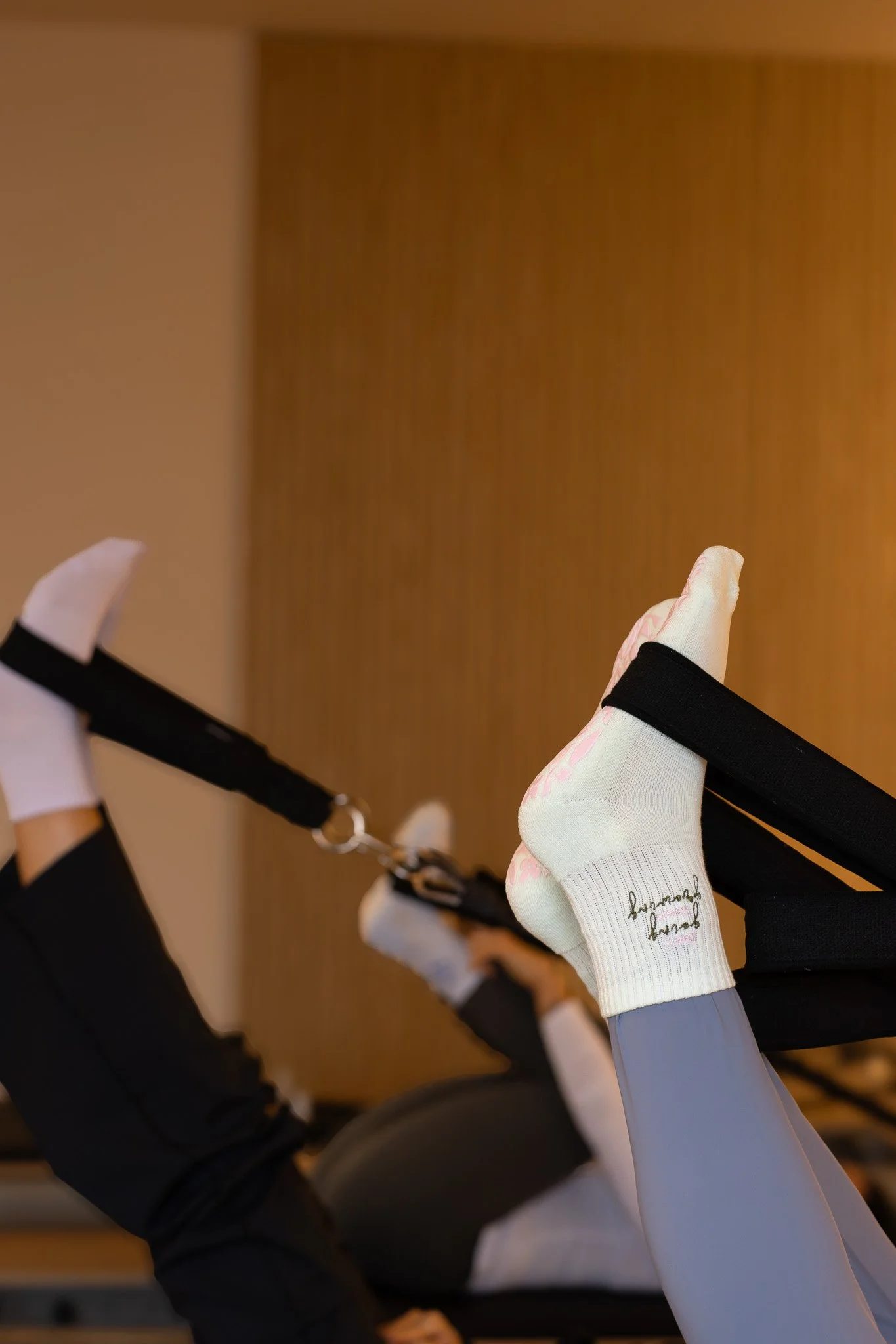 Person in black athletic wear lying on a chair with legs elevated and wearing socks with writing on the side. GetAGrip Apparel.